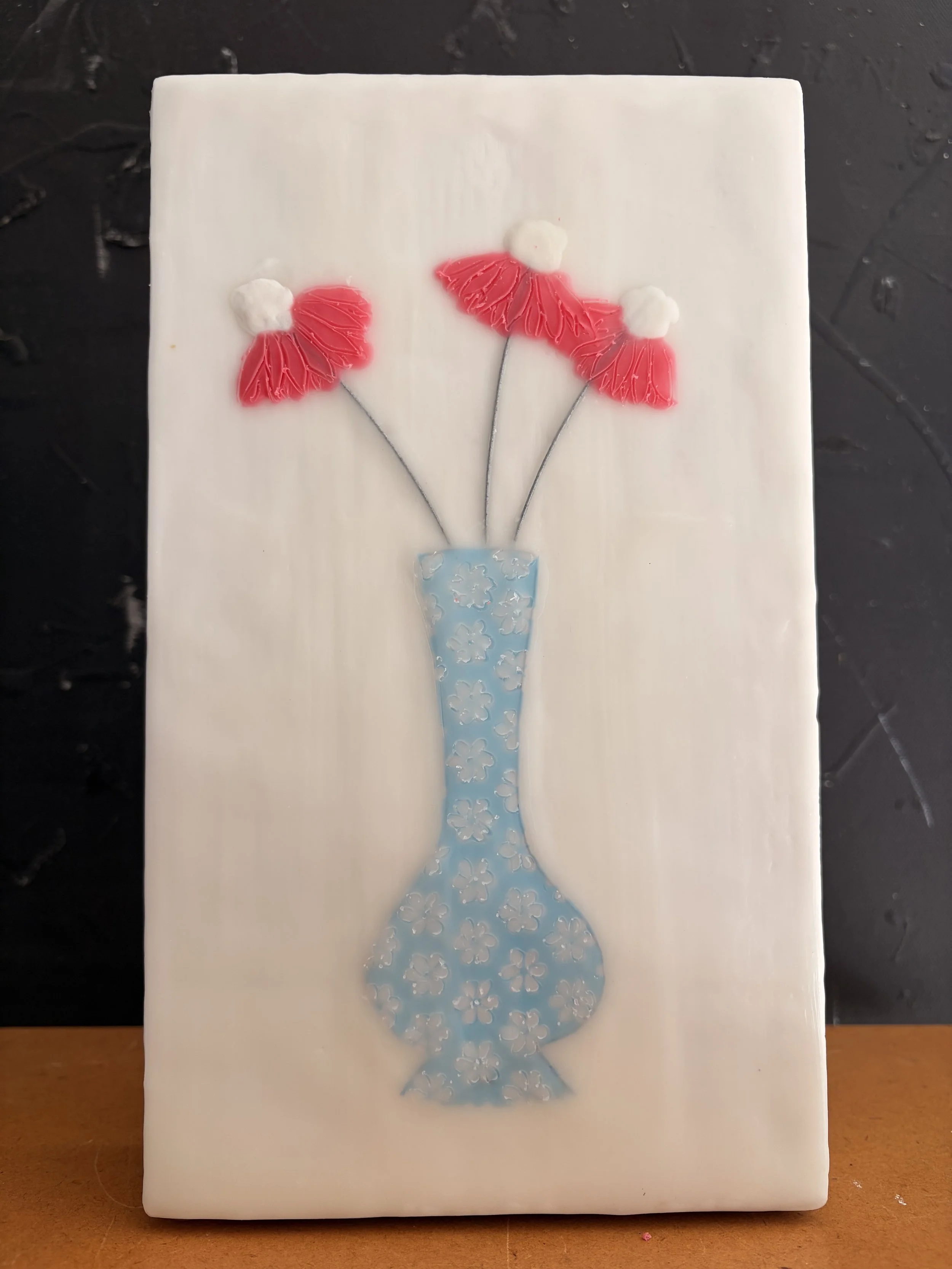 Encaustic wax and mixed media block artworks featuring stylised vases with delicate pink and orange flowers on textured white backgrounds, arranged as a cohesive decorative series.