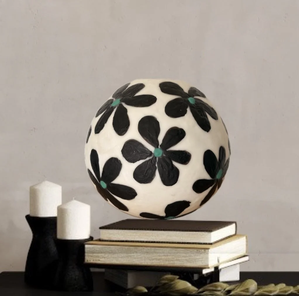 Handmade encaustic wax bowl featuring black floral motifs on a white rounded form, created by artist Karen Canning.