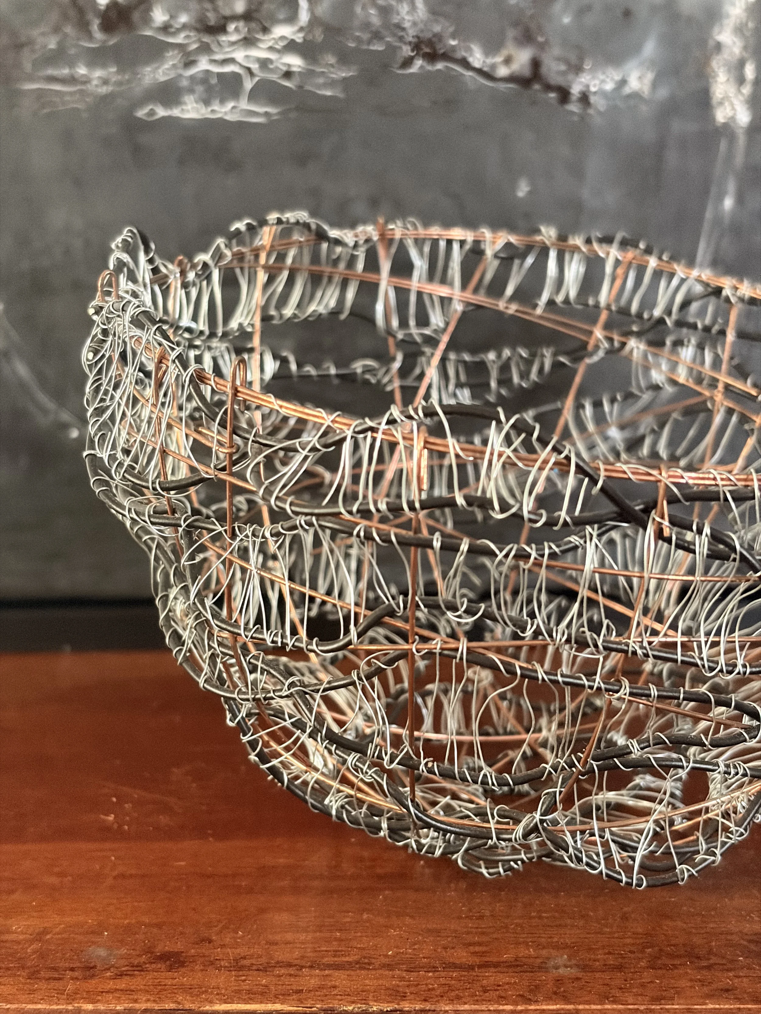 Handcrafted wire sculpture bowl made from copper and steel wire, featuring an organic woven design with layered textures, displayed as a contemporary sculptural vessel.