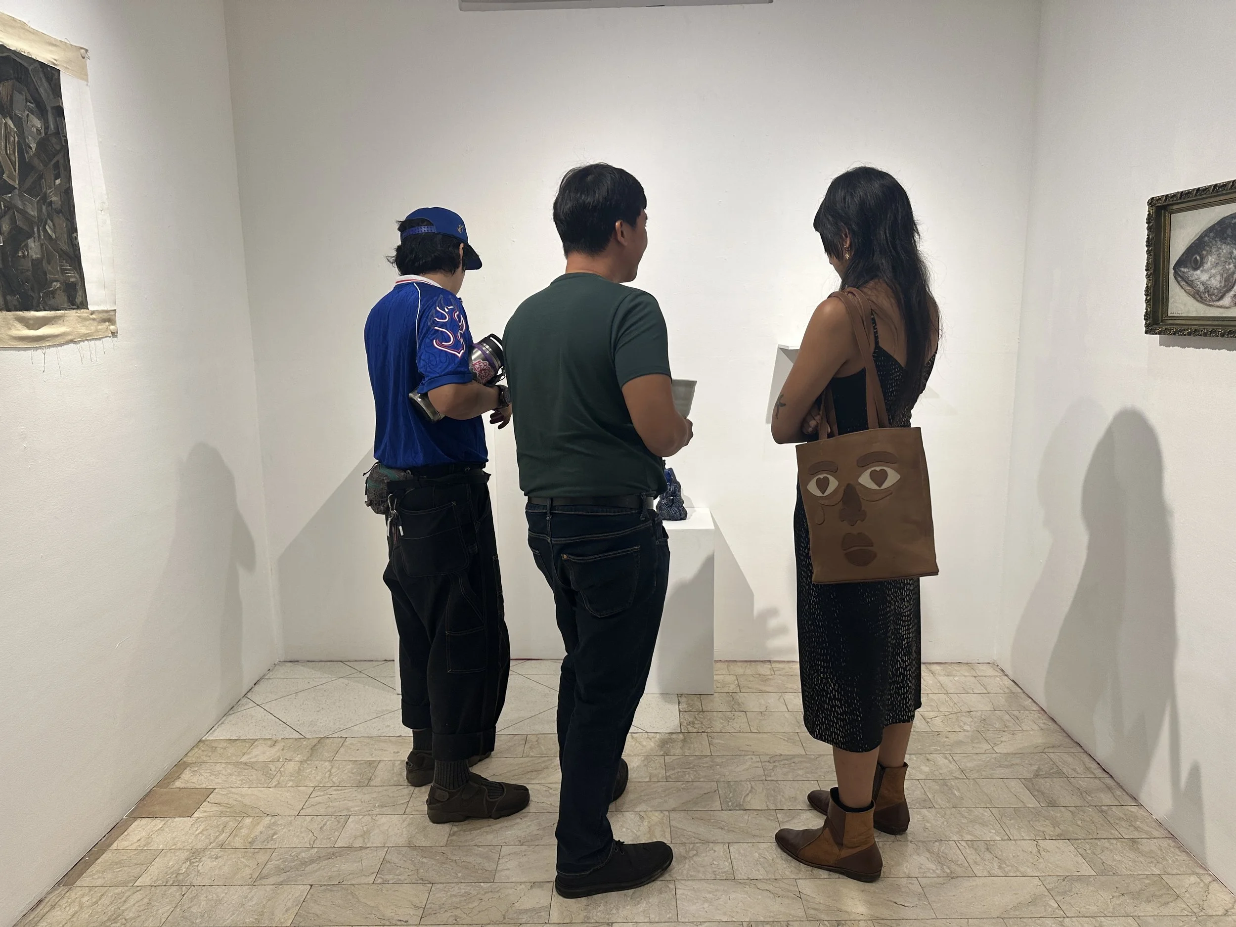 Artist Jose Solon Perfecto talks about his ceramic sculptures at the gallery show opening