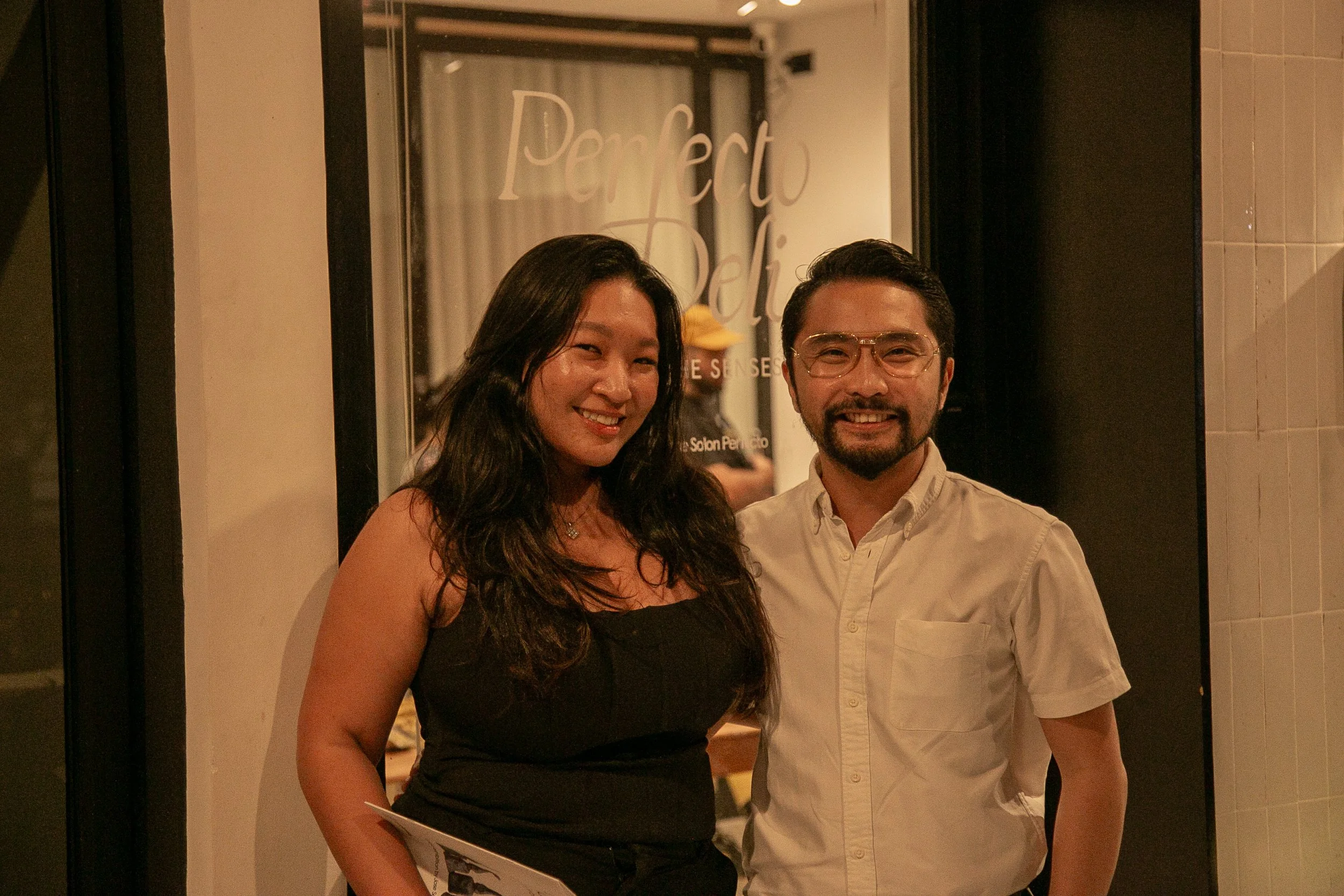 Guests standing in front of Perfecto Deli during the opening night of the art exhibit