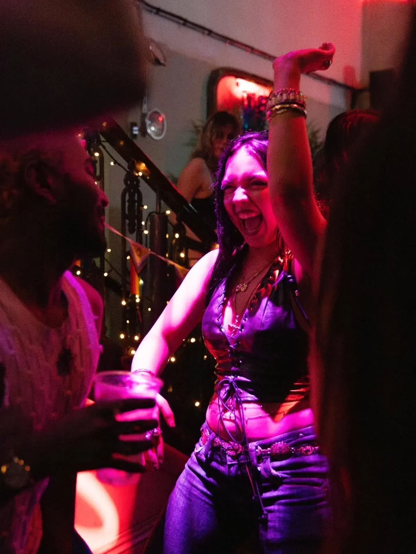 Guest dancing under pink club lighting at Oculist Brighton.