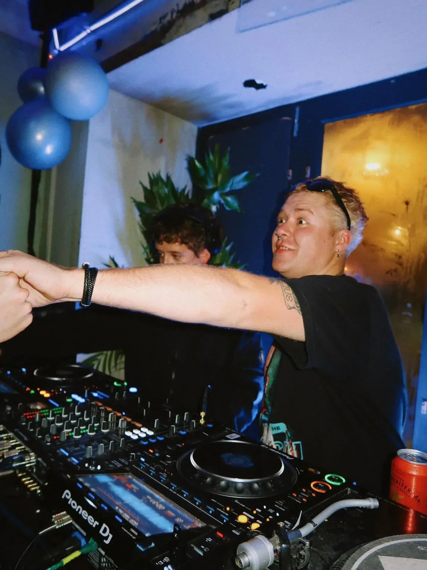 DJ reaching across the decks during a student night at Oculist Brighton.
