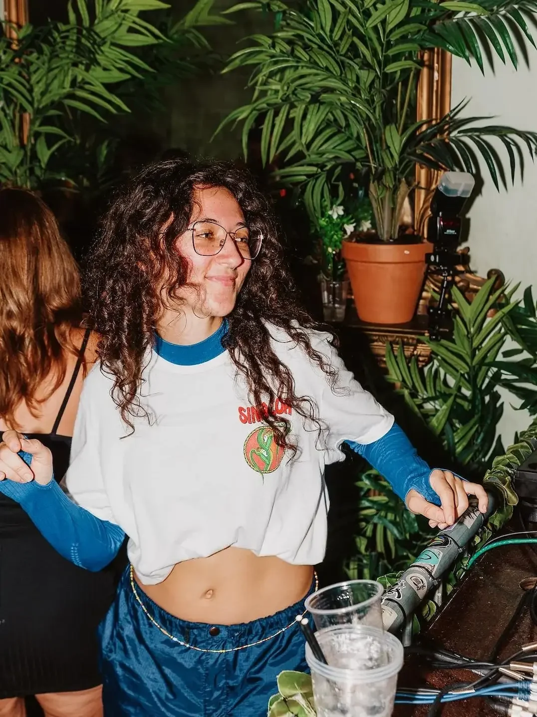 Guest dancing beside plants on the roof terrace at Oculist Brighton.