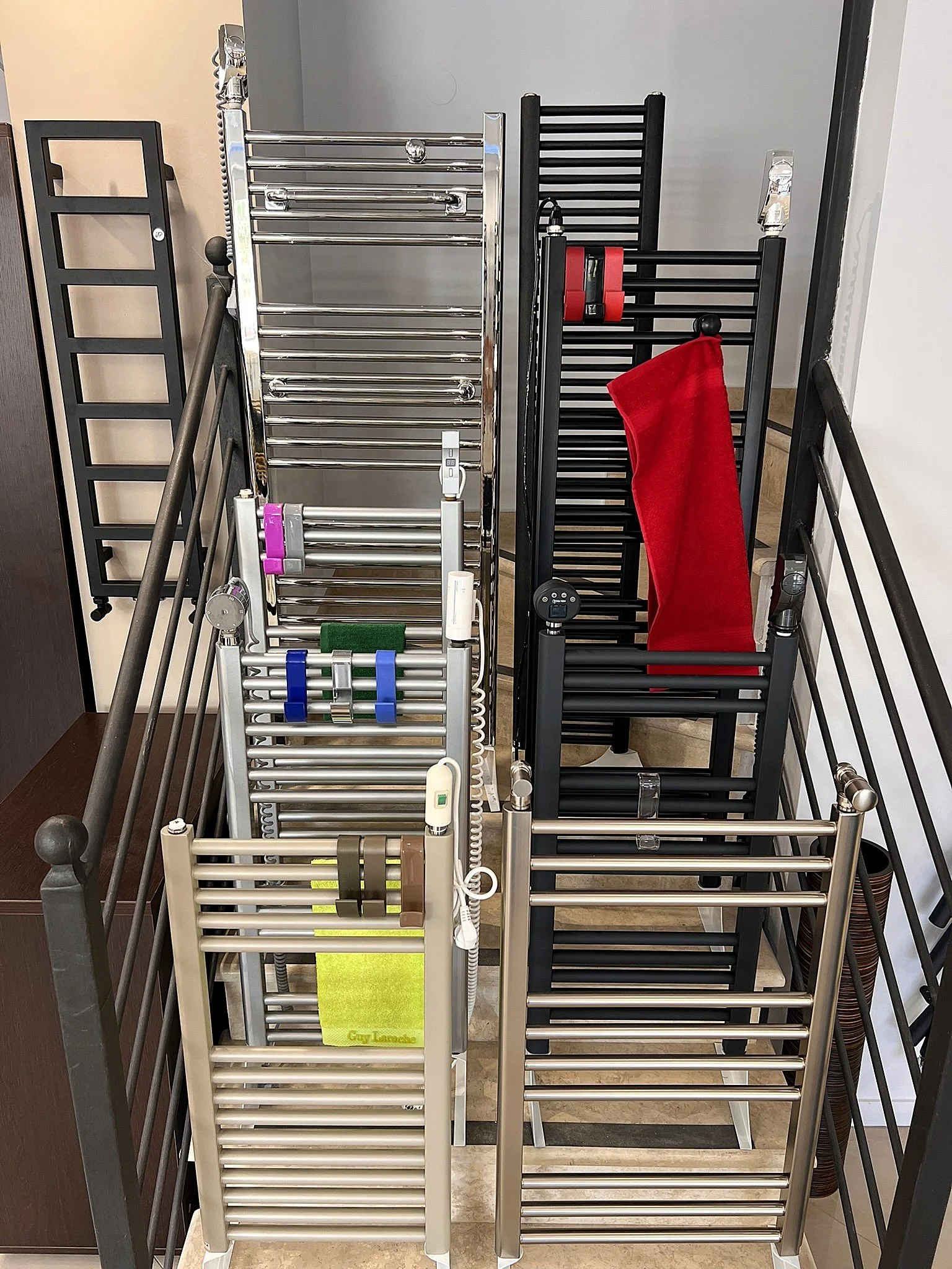Interior view of the Tsolakidis showroom featuring a wide selection of modern decorative radiators, including vertical heating panels, mirror-style radiators, and colored designer units for both living spaces and bathrooms