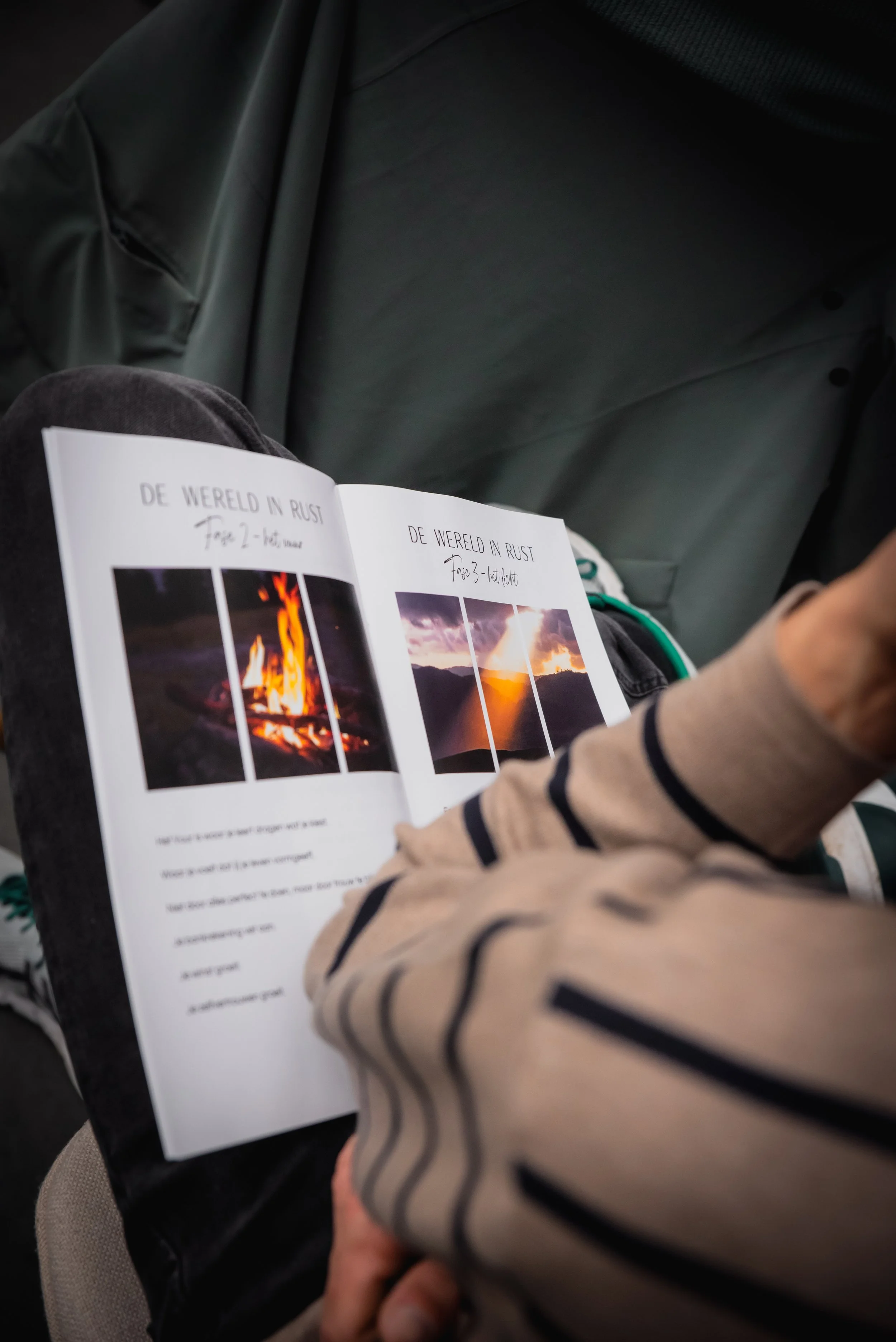 Persoon leest een boek met foto's van een kampvuur en een berglandschap.