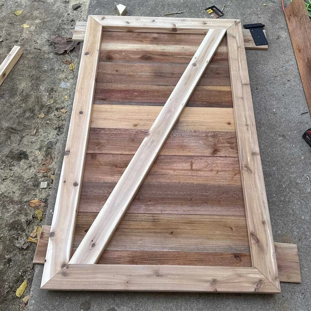 Unfinished wooden frame with a rectangular shape, lying on a concrete surface, surrounded by small tools and pieces of wood.