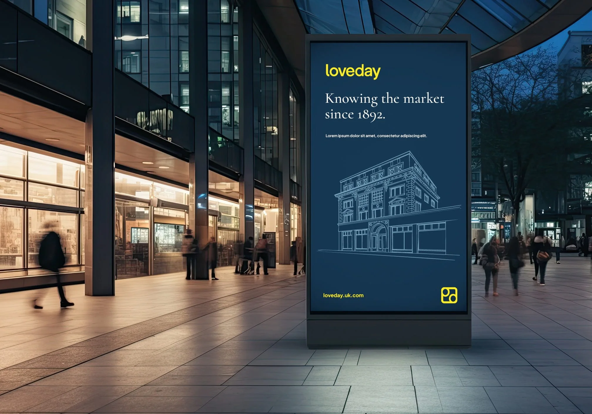 An outdoor advertising billboard in a city setting displaying information about Loveday, a company with roots since 1892, including a line drawing of a historic building. The background shows modern glass and steel building. Design by Hubble.