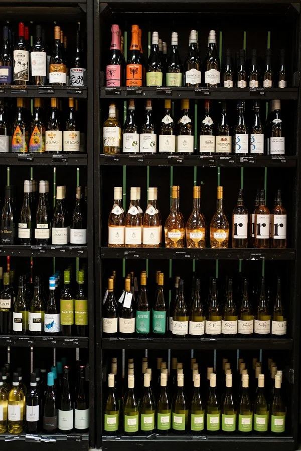 Shelf of assorted wine bottles in a liquor store.