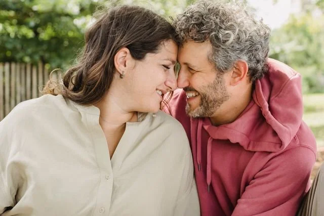 Couple laughs with their heads close together