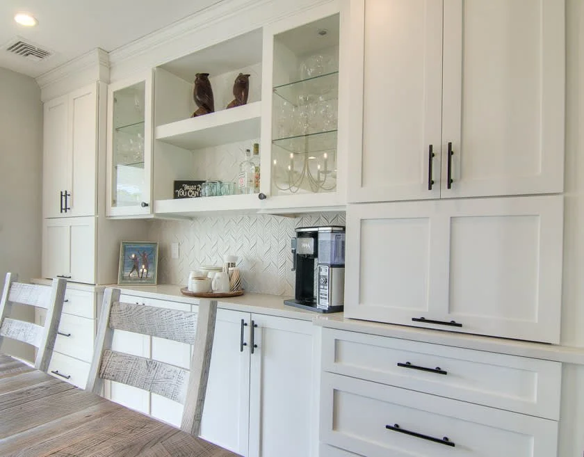 White cabinetry with black hardware and a coffee station.