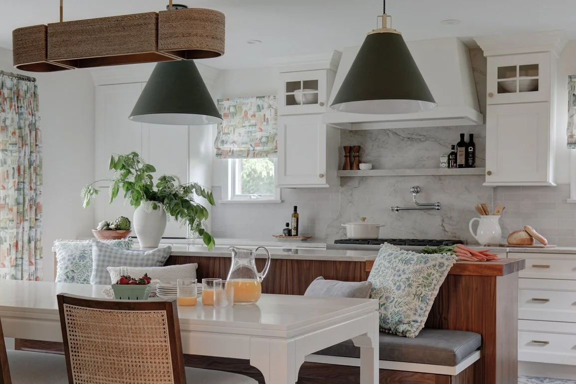 Kitchen dining table with bench seating and green pendant lights.