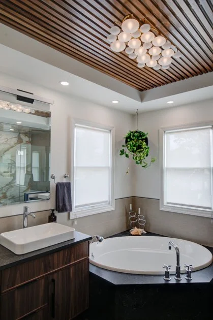Bathroom with circular tub and wood slat ceiling.