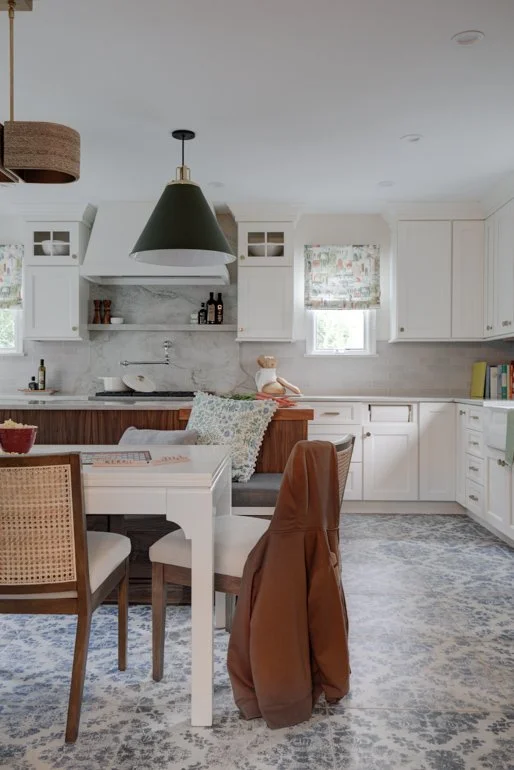 Kitchen dining area with white table and patterned blue tile floor.