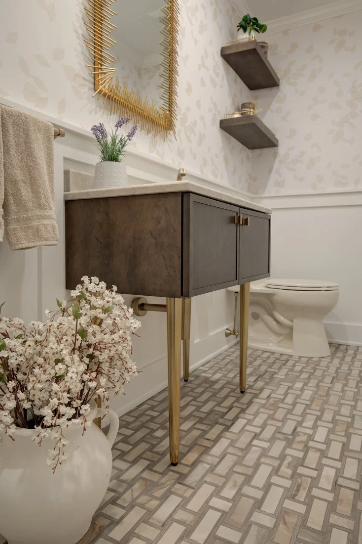 The modern bathroom features gold accents.