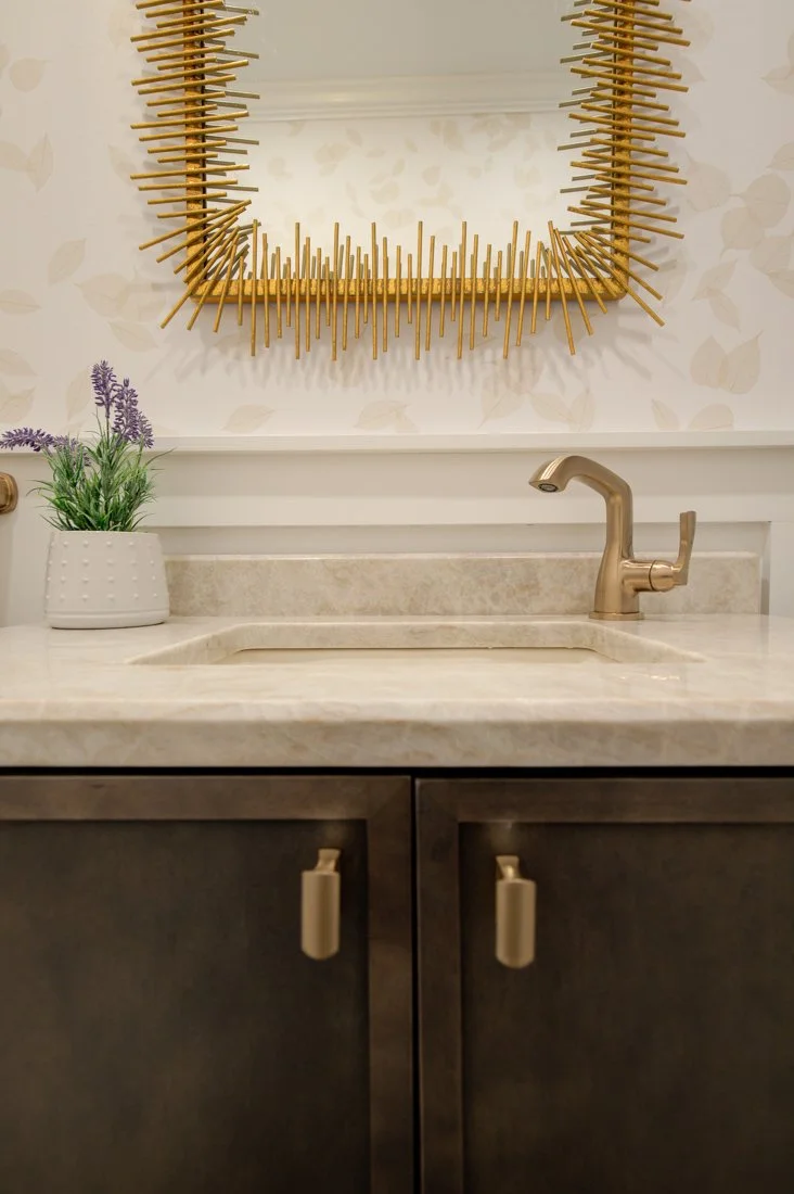 Bathroom vanity with gold faucet.
