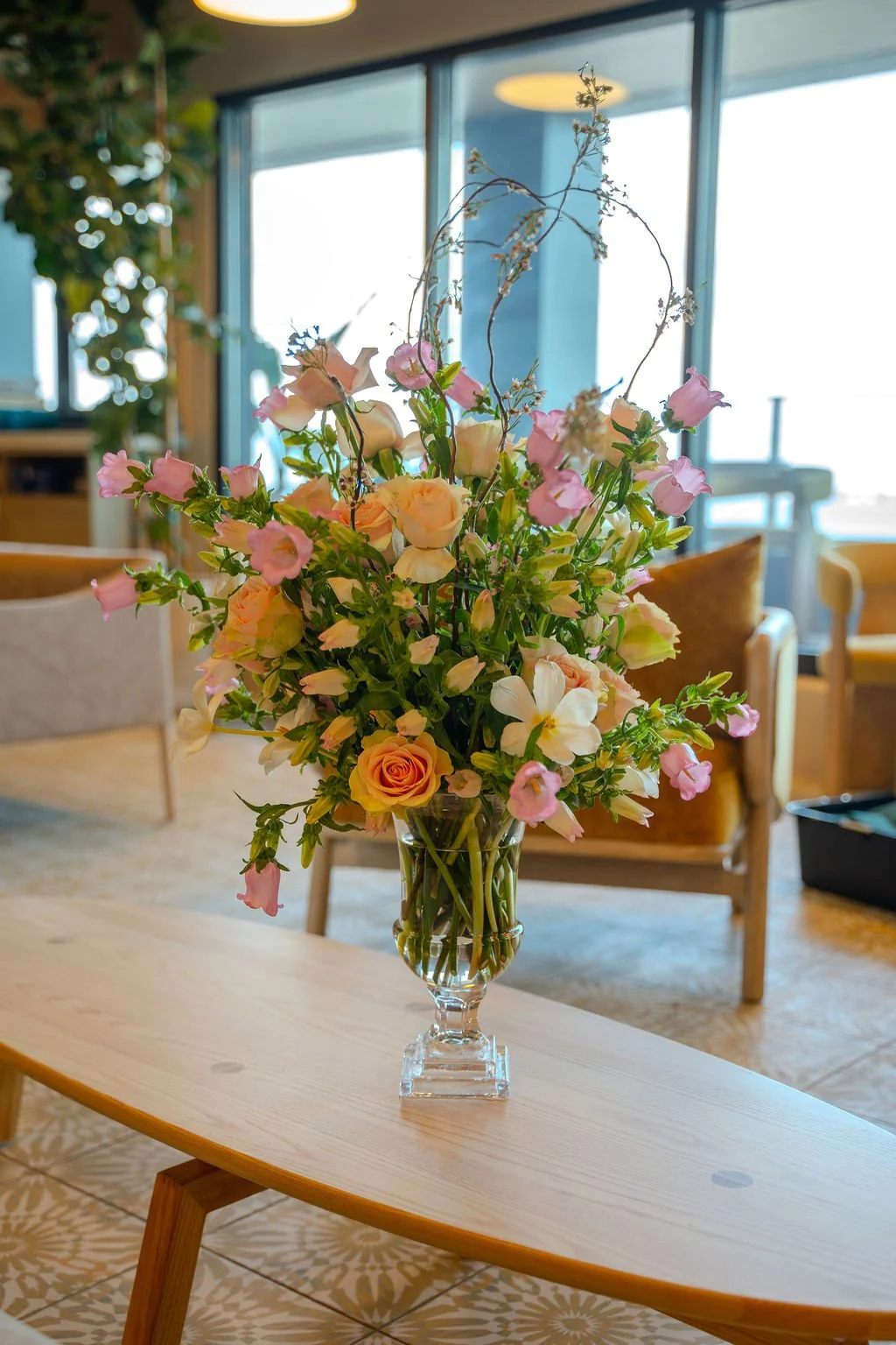 Floral arrangement displayed on a coffee table at the Maru grand opening event in Tampa, Florida, featuring soft pastel blooms and greenery