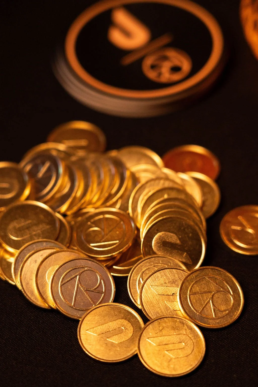 Editorial close-up of custom gold coins created for the DoorDash x SevenRooms market launch party, styled as a luxury branded detail on a dark tabletop
