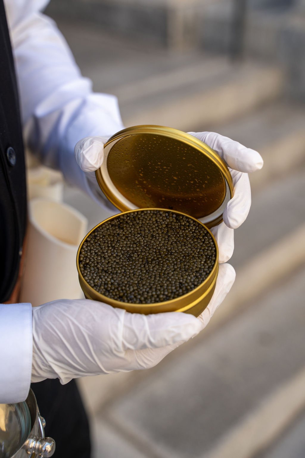 Luxury caviar service at a brunch event in Tampa, Florida, featuring a server presenting an open tin of premium caviar
