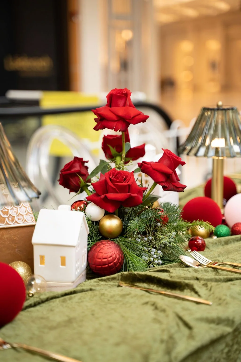 Holiday Christmas table setting with red roses, festive decorations, and elegant gold cutlery for the International Plaza Christmas Launch Party