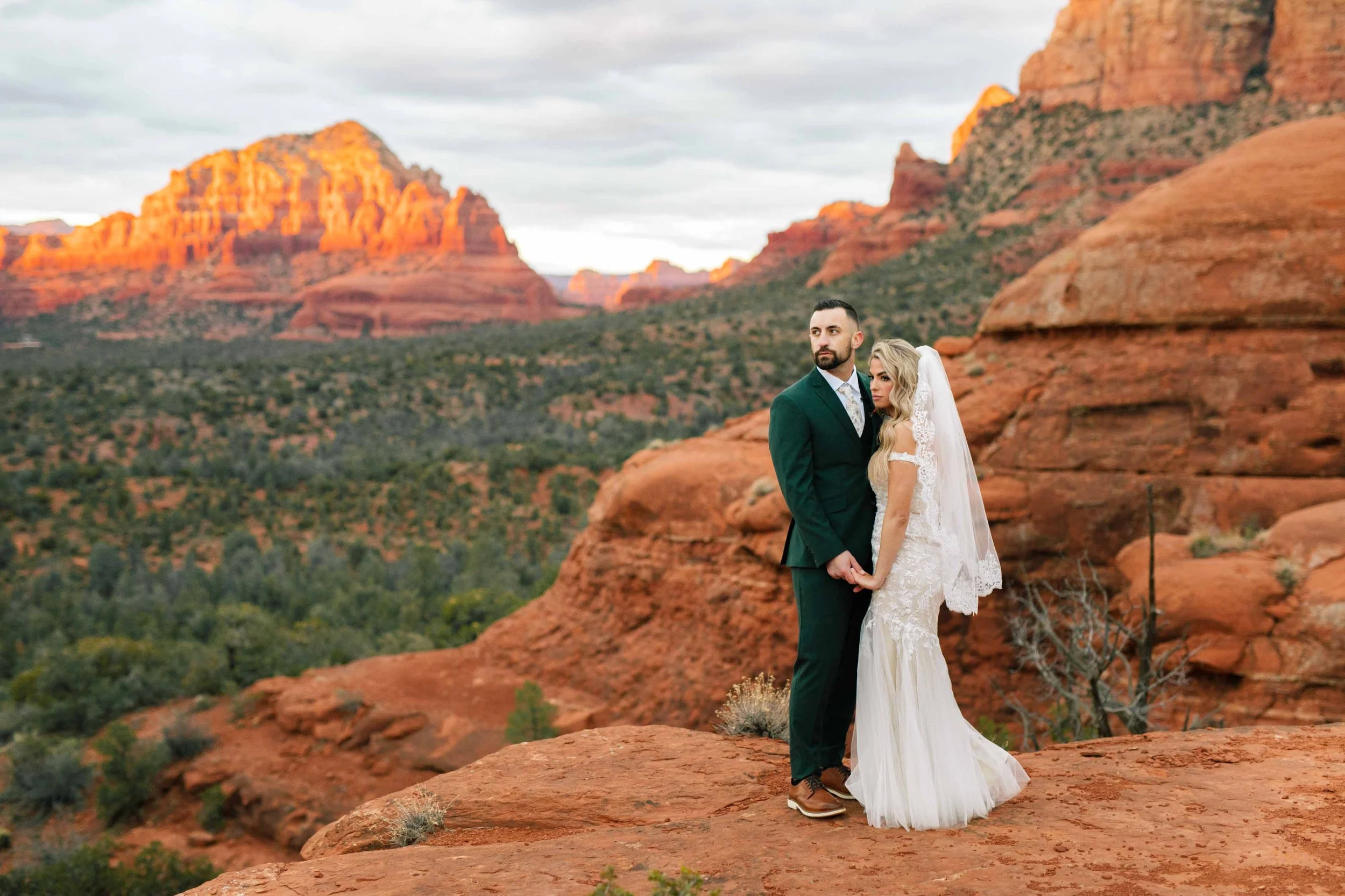 Beautifully lit Sedona red rocks with Earth Elopement wedding couple at Baby Bell rock