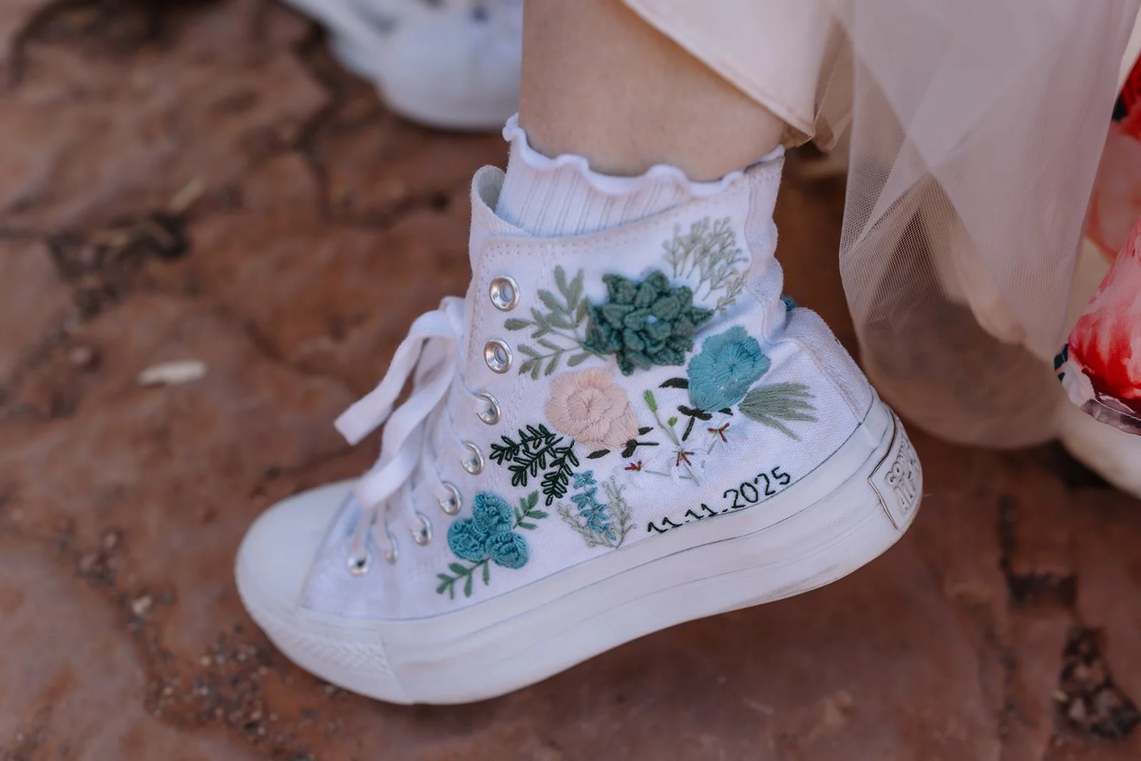 Close up of Sedona Bride's decorated high-top sneaker. Embroidered flowers and wedding date.
