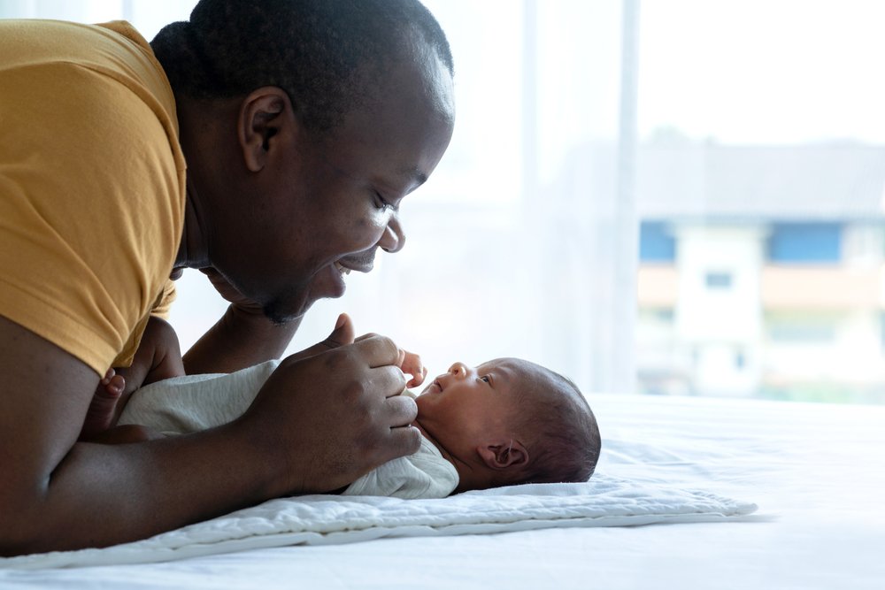 A new father looking at and smiling at his newborn baby | SACCounty Healthy Beginnings
