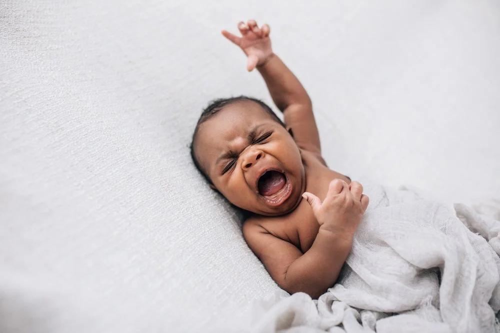 Crying baby with arm extended
