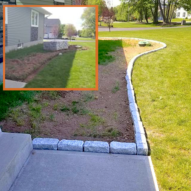 A landscaped yard with a curved stone border separating the grass from a newly dug flower bed or lawn area, with a sidewalk in the foreground.