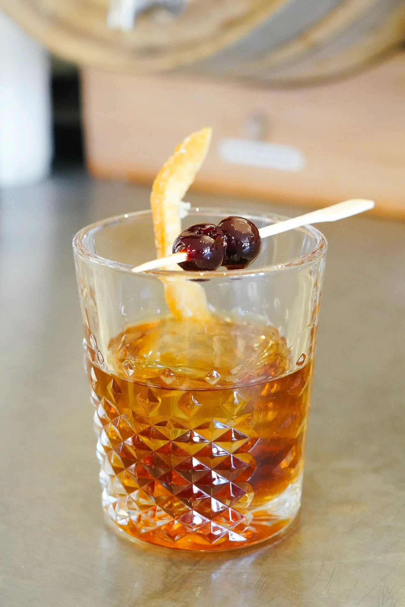Old fashion drink with orange peel and cherries