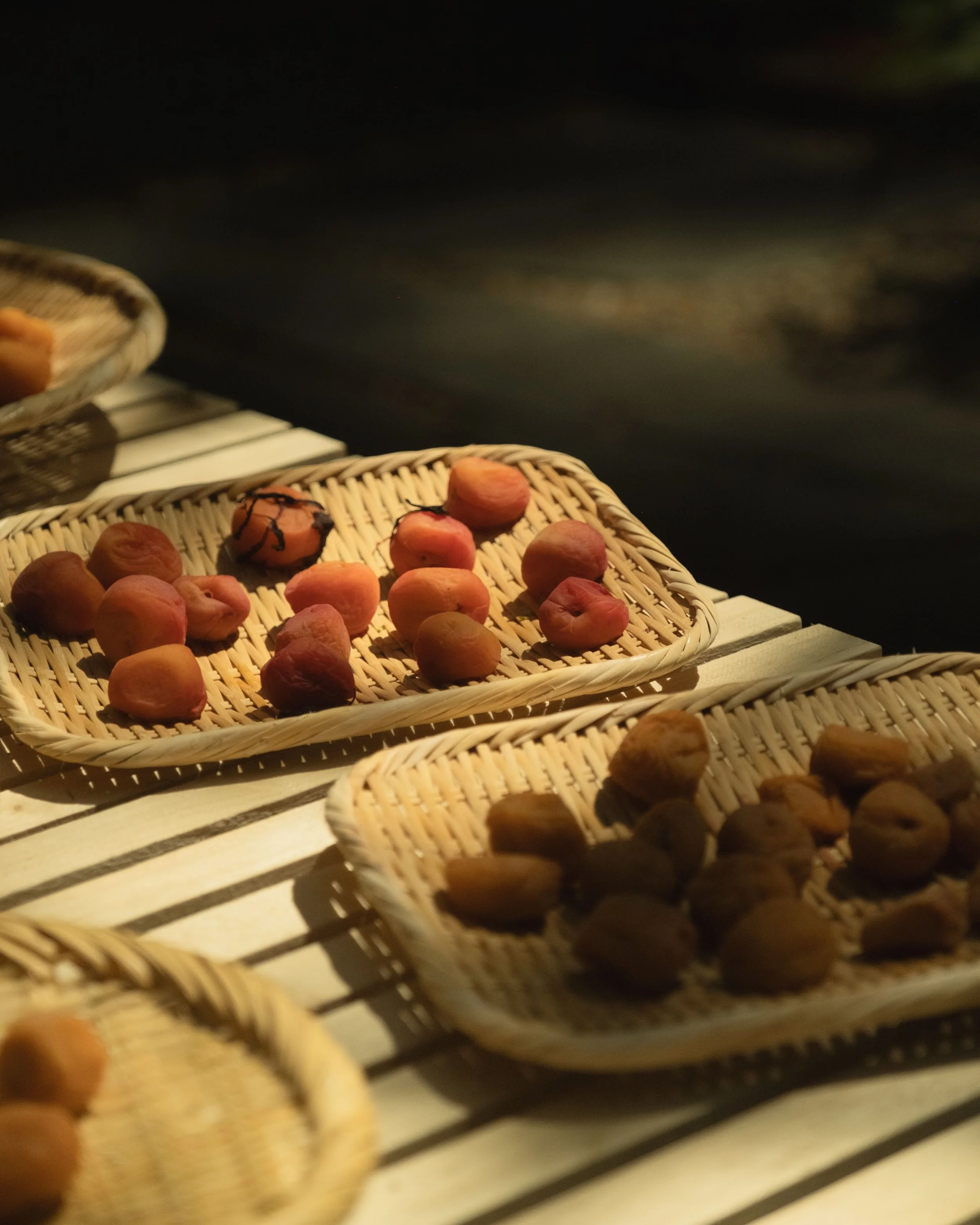 Basket of peaches and figs on a wooden surface.