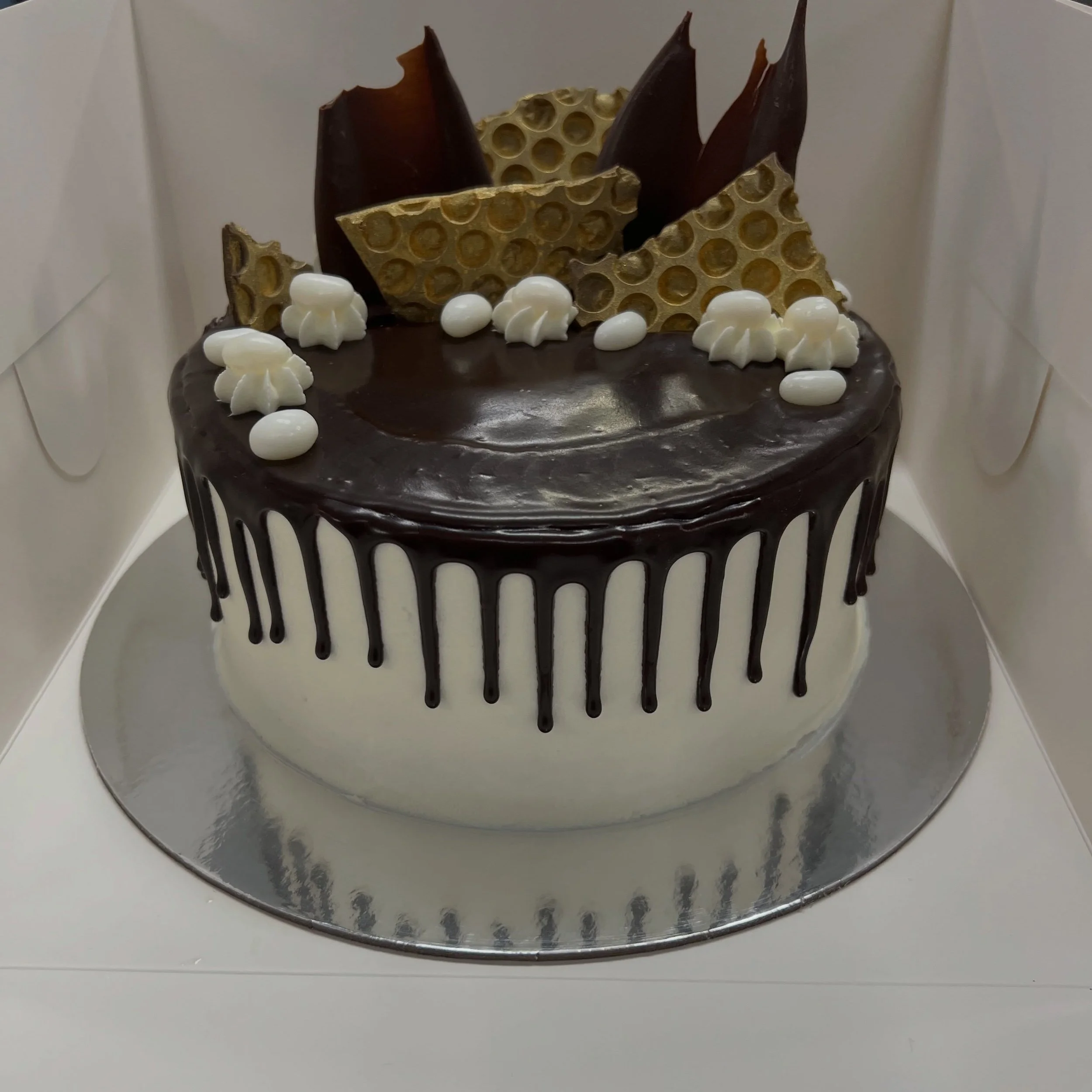 Double layer Drip Cake 🎂
This is one of our most popular cakes! Available in Gold or Silver decorations 💛🩶

All of our products are 100% vegan, gluten &amp; nut free 

Order online: https://www.gilbertandmarcel.com.au/menu/p/party-time-cake-nf2zl-