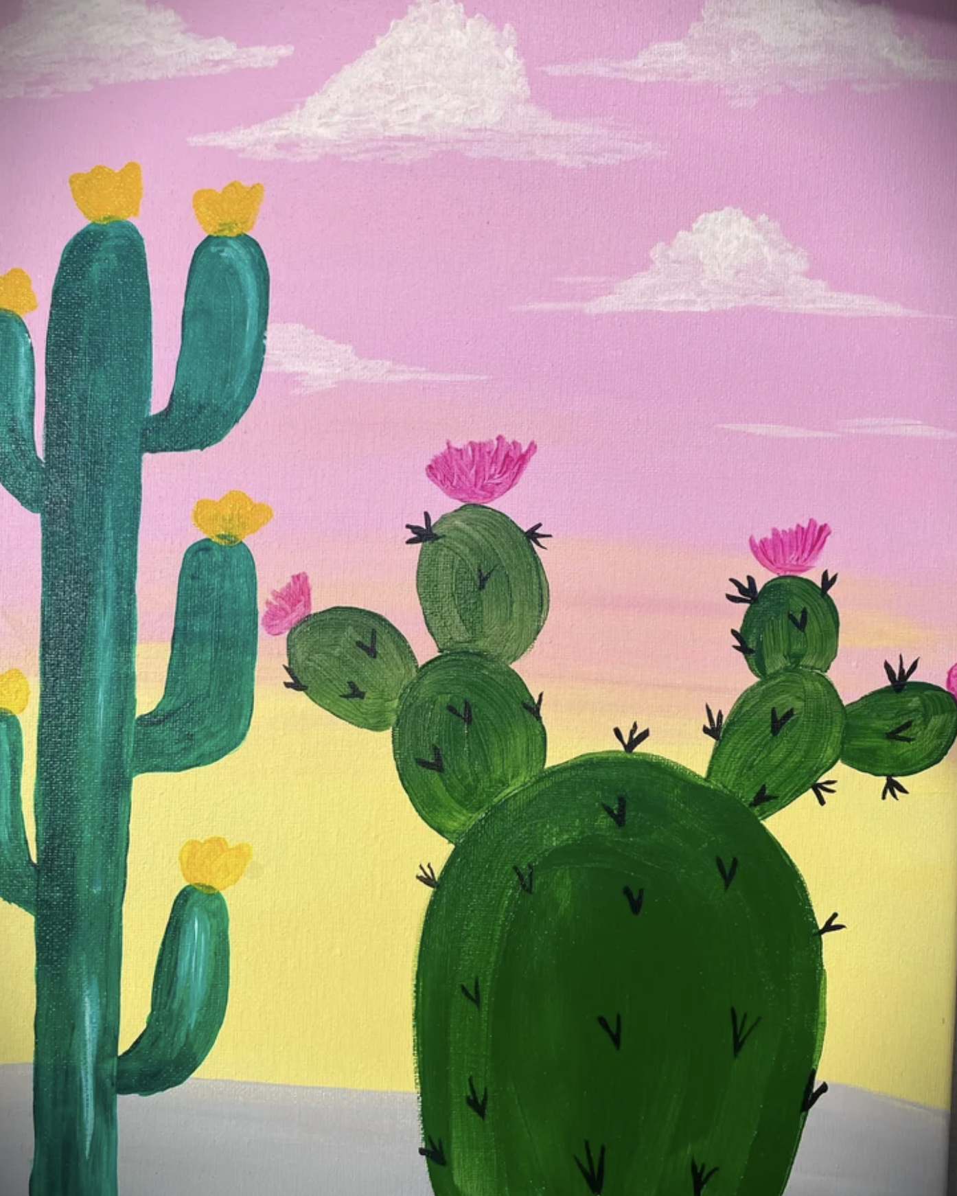 Colorful painting of cactus plants with pink flowers under a pink and yellow sky with white clouds.