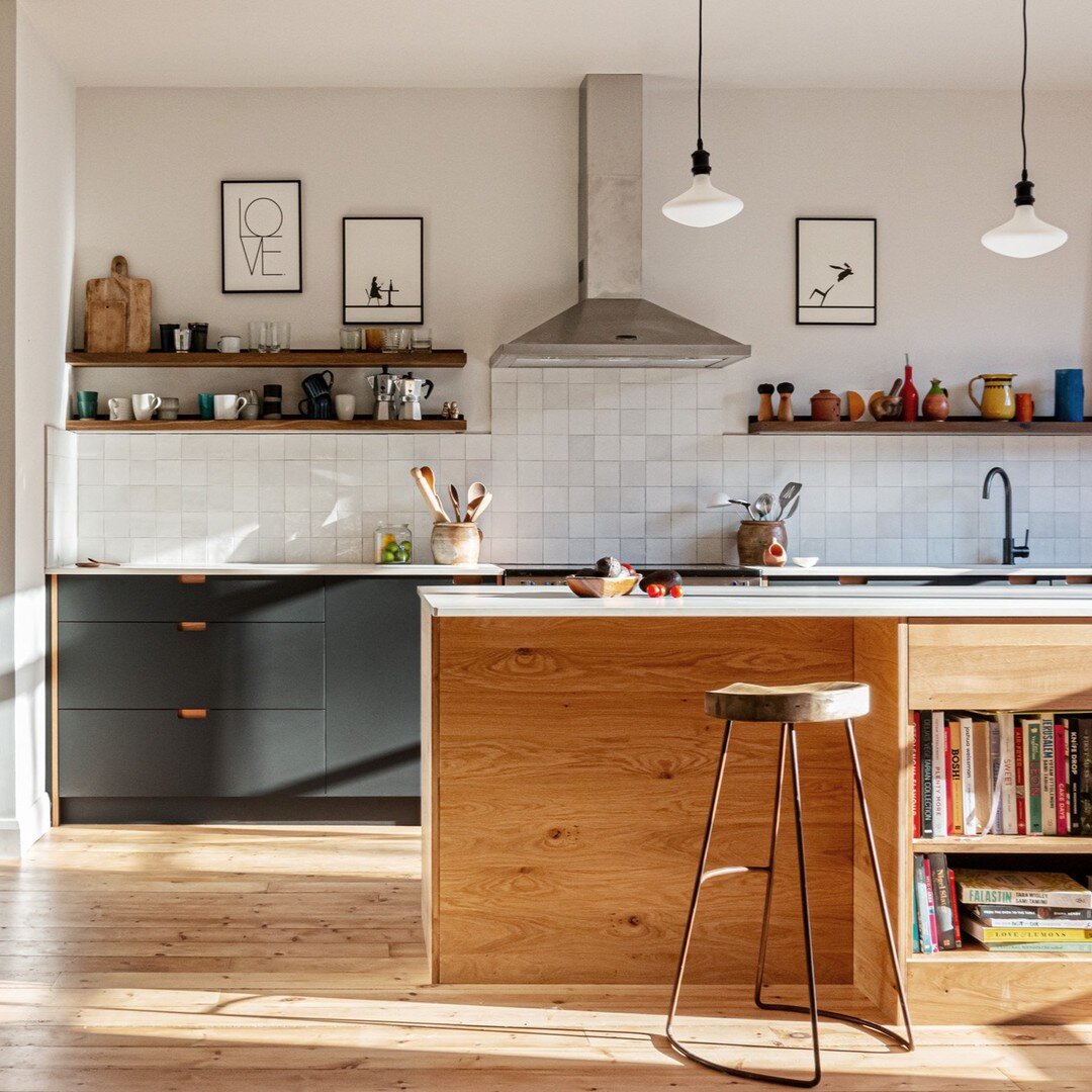 A beautiful bright family kitchen. Matte grey Fenix doors soften the light streaming in, oak details throughout the space provide depth and contrast.
