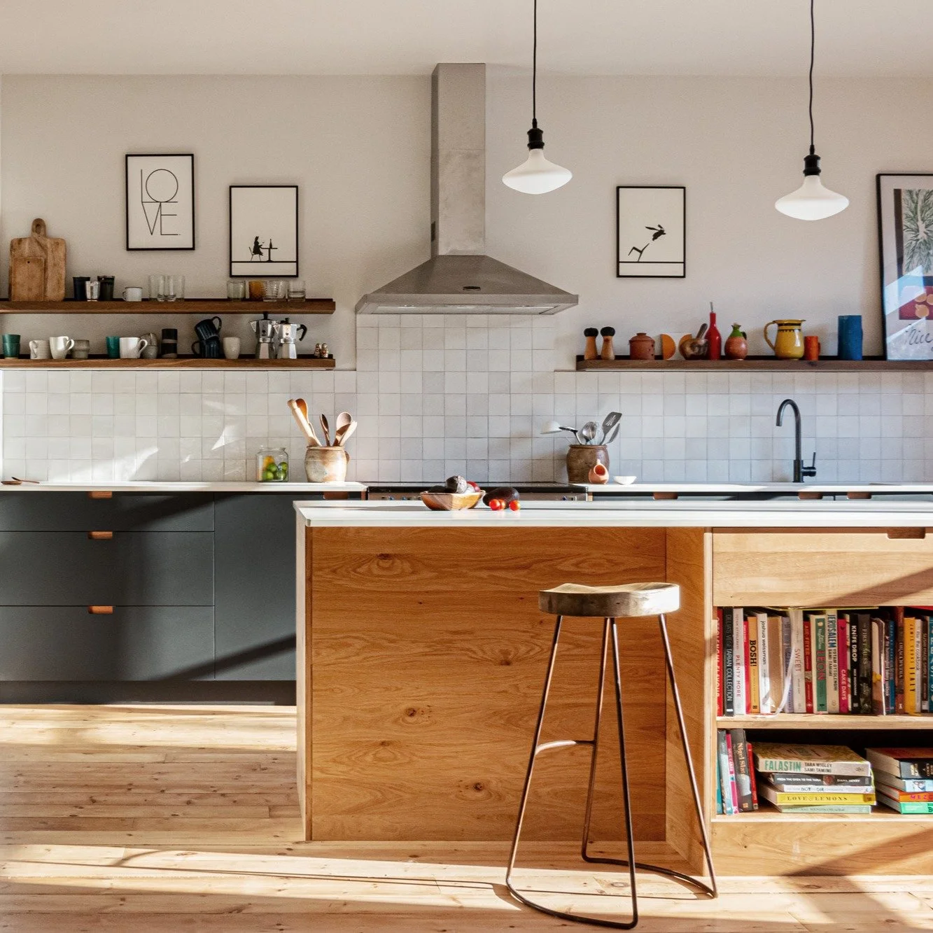 A beautiful bright family kitchen. Matte grey doors soften the light streaming in, oak details throughout the space provide depth and contrast.
