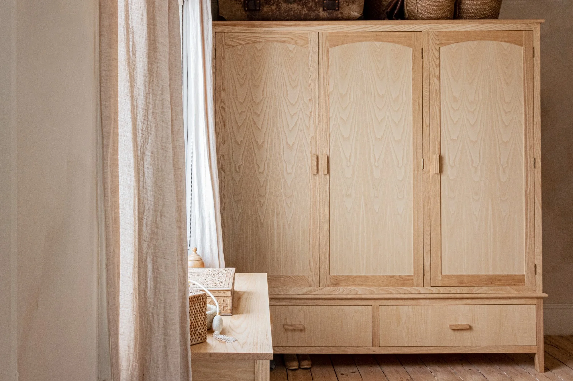 A Shaker style solid ash wardrobe with beautiful wood grain in a serene dressing room