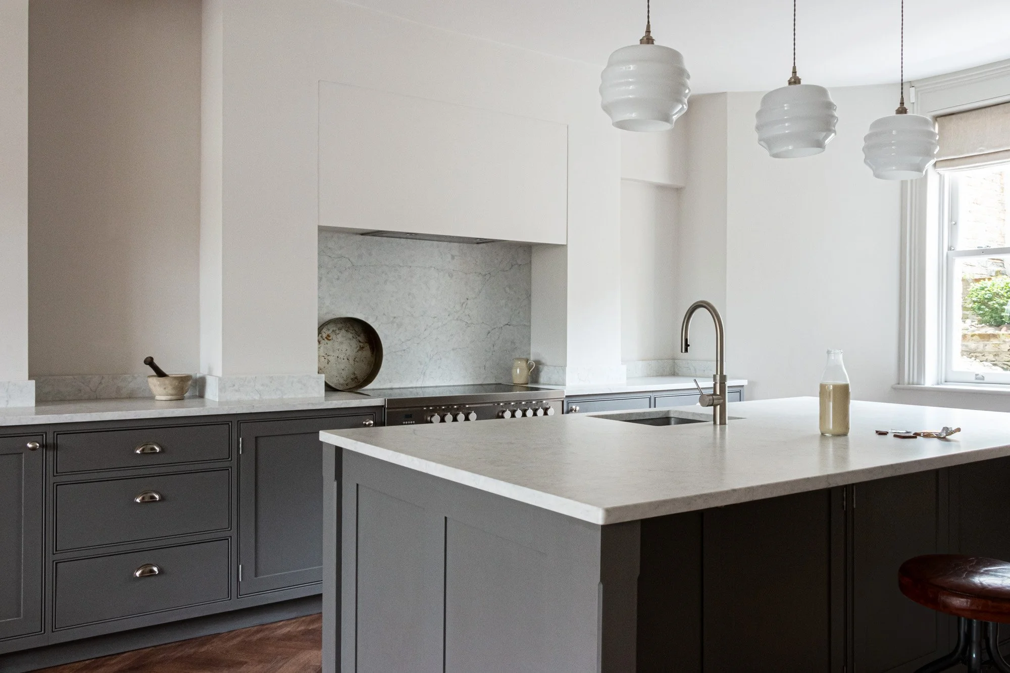 Looking across a grey kitchen island in a bespoke shaker kitchen