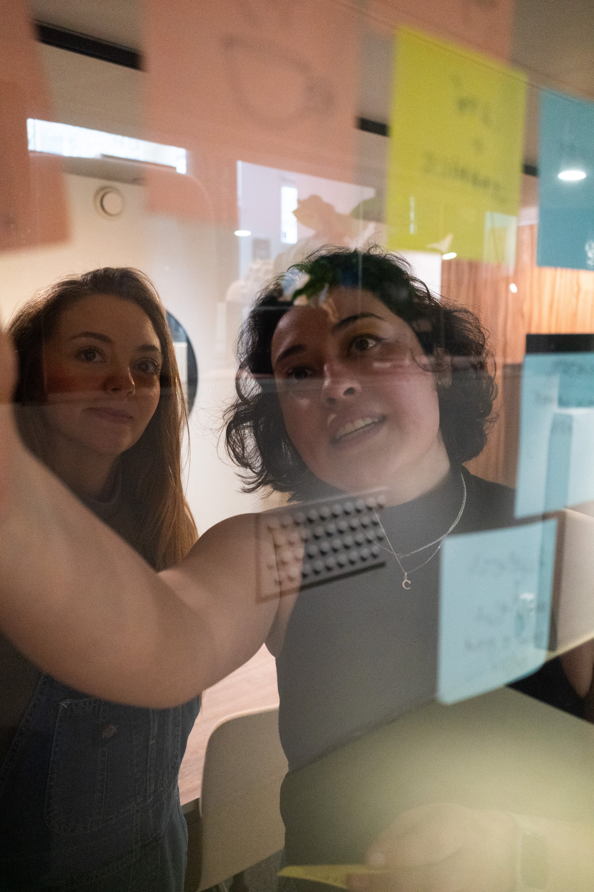 Workshop participants working with sticky notes on a glass wall