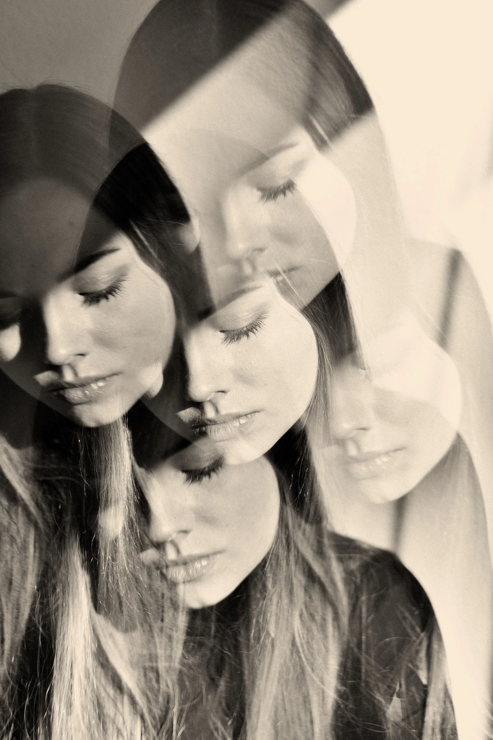 Black and white sepia double exposure portrait of a woman, suggesting layered emotional experience.