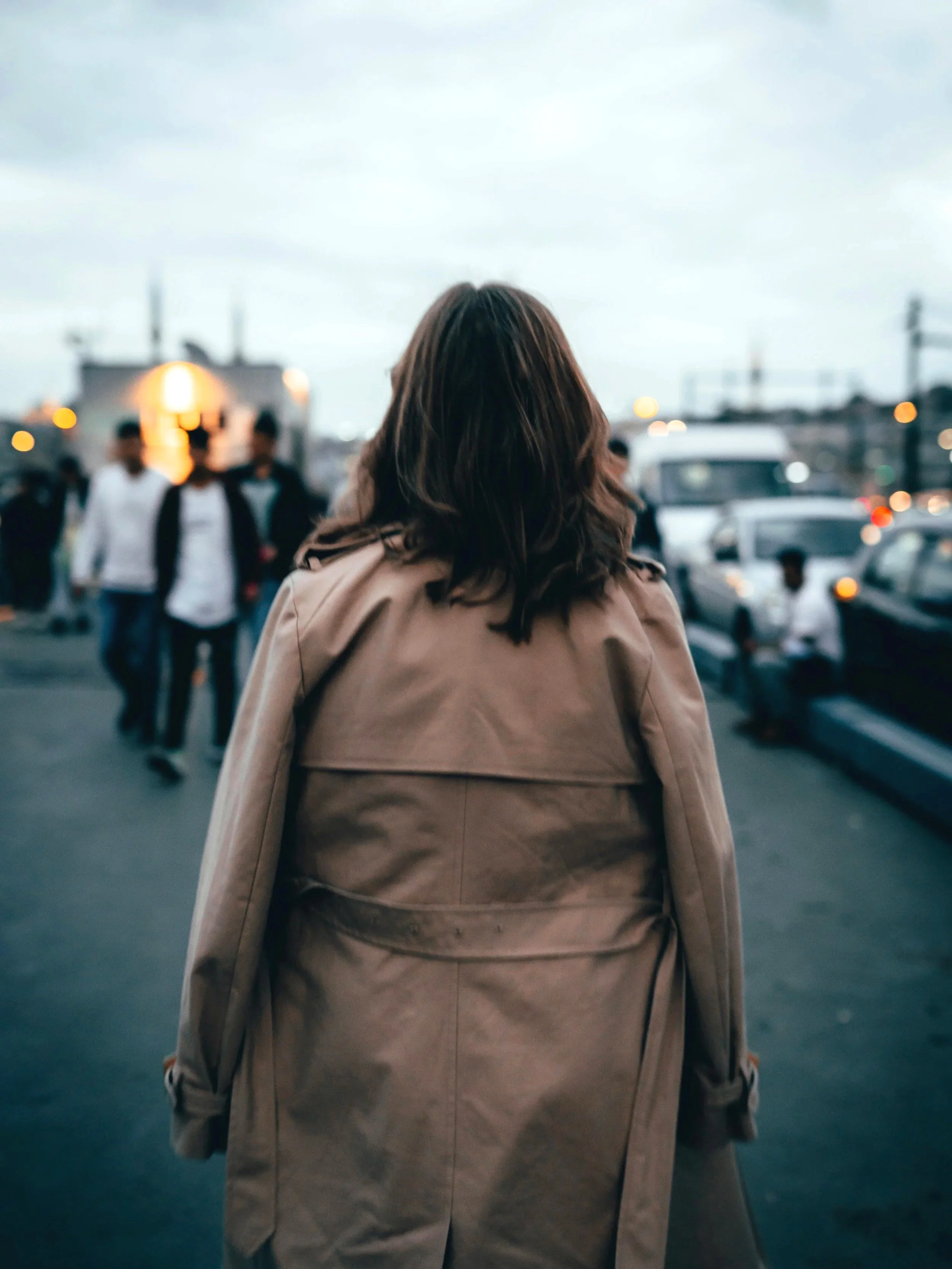 A person navigating a crowded city, seen from behind, capturing the feeling of transition, searching for grounding in a new place.