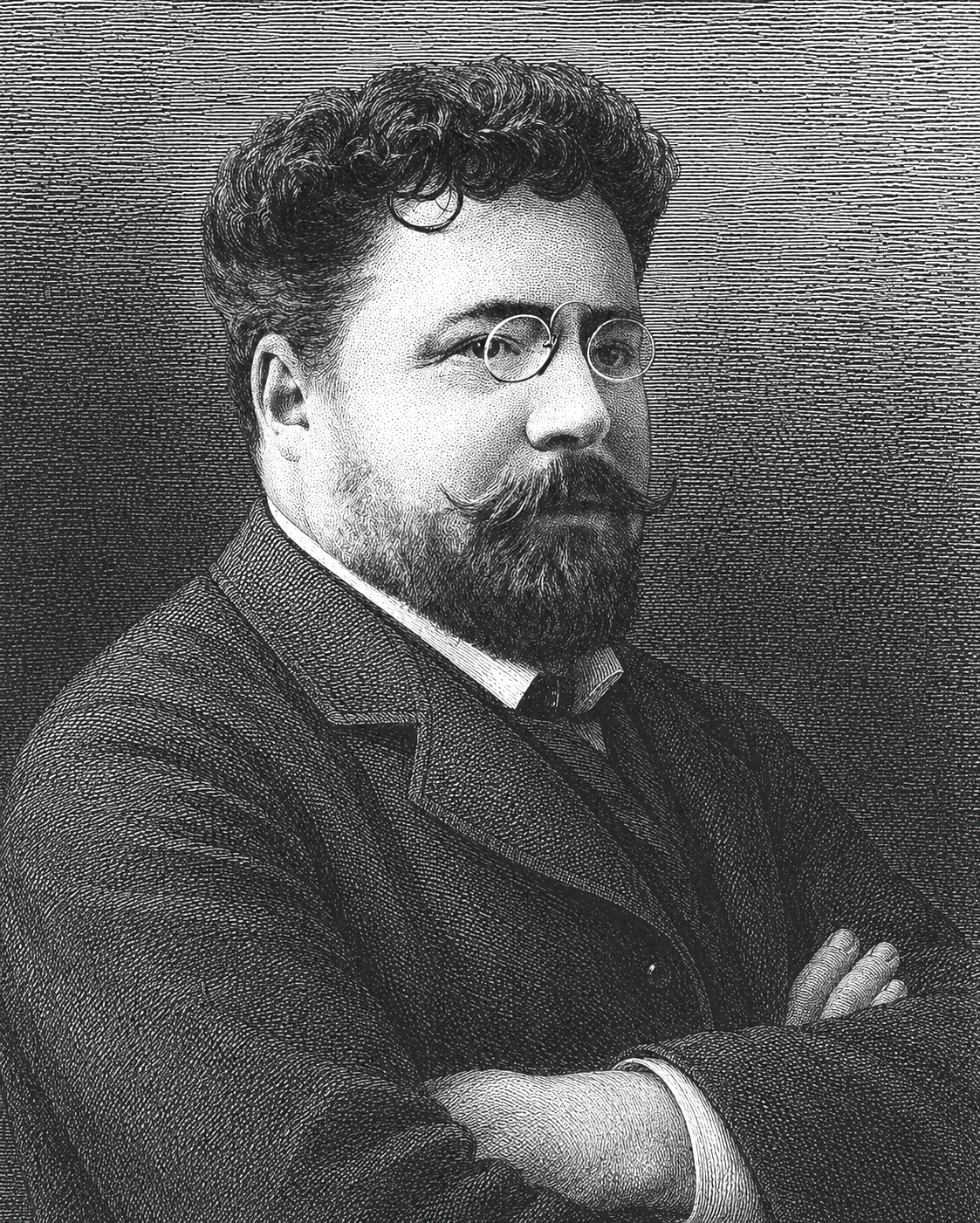 Portrait en noir et blanc de Gaston Leroux avec une barbe, moustache et cheveux bouclés, portant des lunettes rondes, une veste et une chemise, avec les bras croisés.