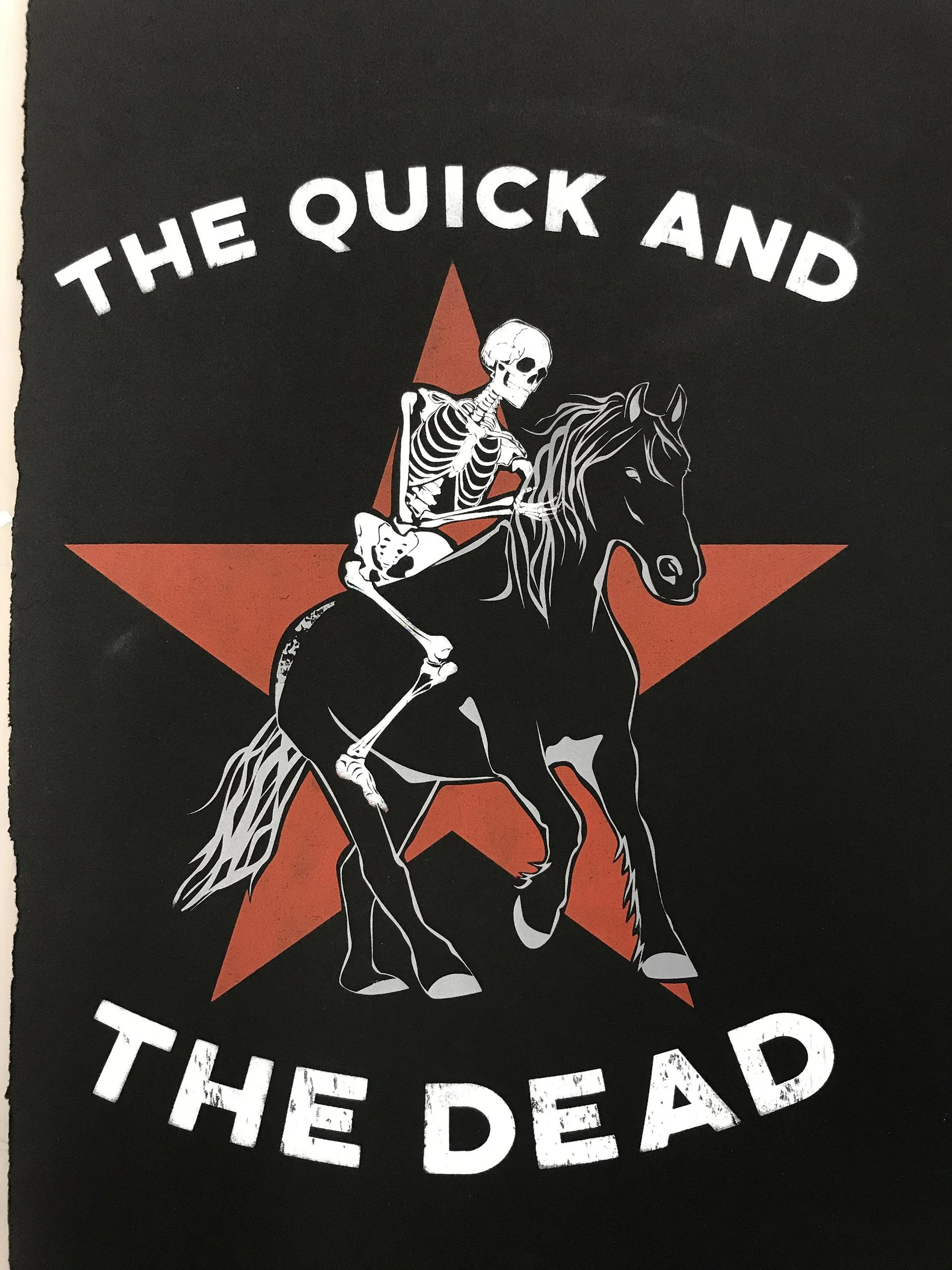 Skeleton in cowboy attire riding a black horse, with red star and white text that reads 'The Quick and the Dead'.