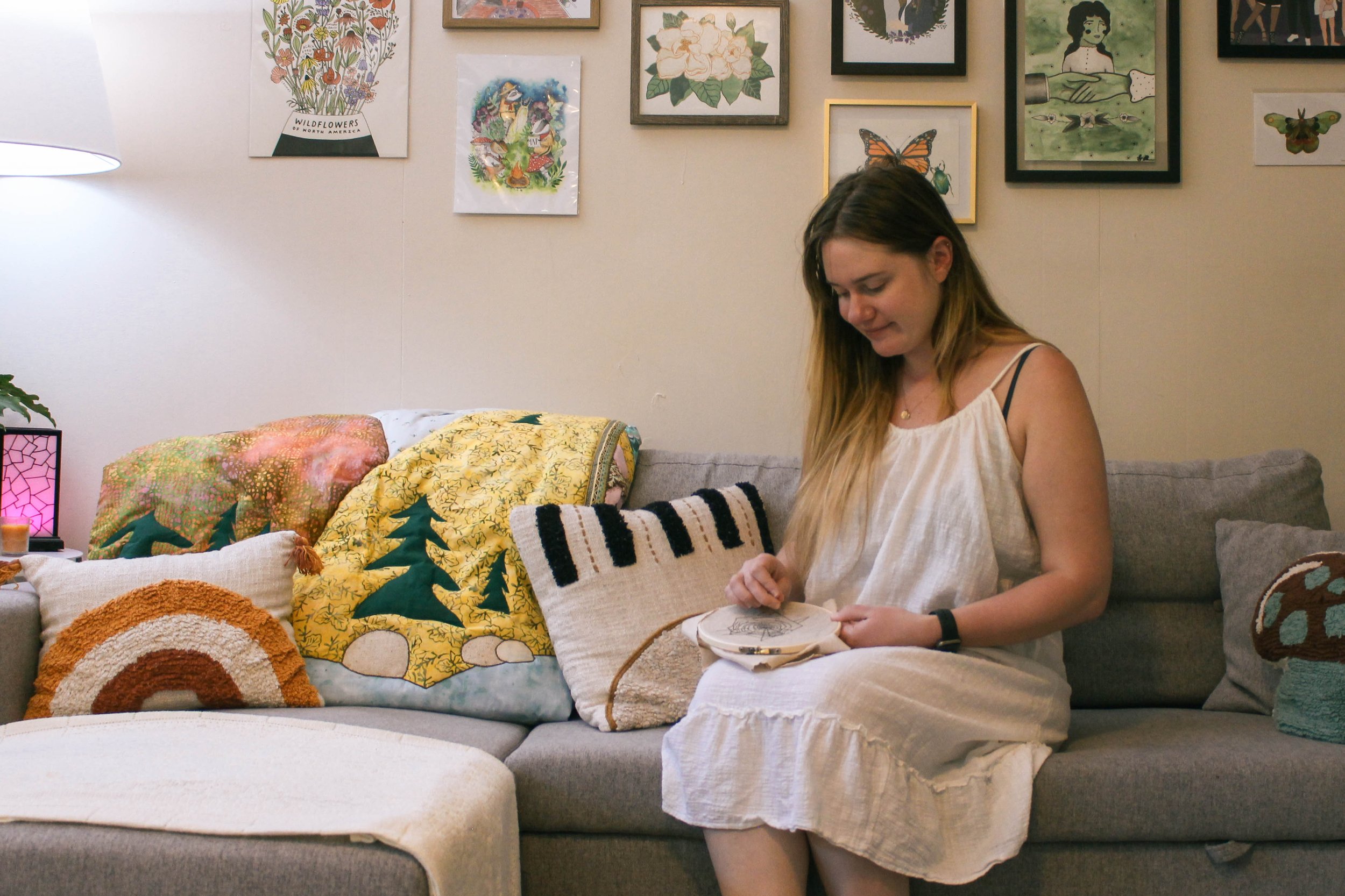woman embroidering, crafting on a couch