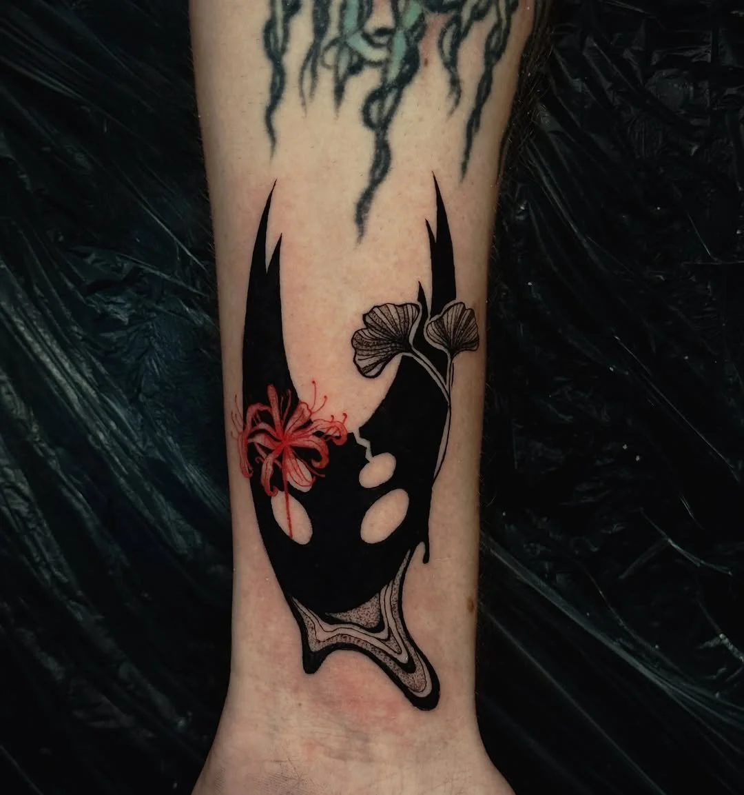 Bold blackwork piece featuring Ichigo's Hollow mask alongside red spider lilies and ginkgo leaves — a suminagashi-influenced Bleach tattoo. By Stella Sanchez (@umbra.inks), now booking at Dark Water Tattoo Studio in Berkeley.
