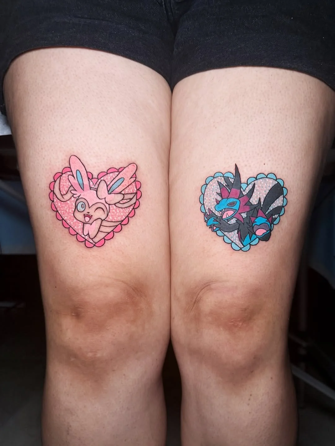 
Matching glitter Pokémon tattoos in heart frames — a pastel Sylveon and a Hydreigon. By Stella Sanchez (@umbra.inks), now booking at Dark Water Tattoo Studio in Berkeley, CA.