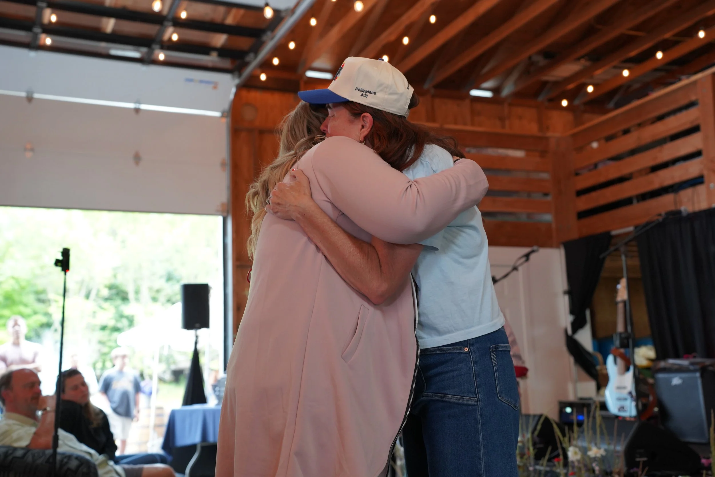 Kimmee Auxier and Guest embracing in a hug.