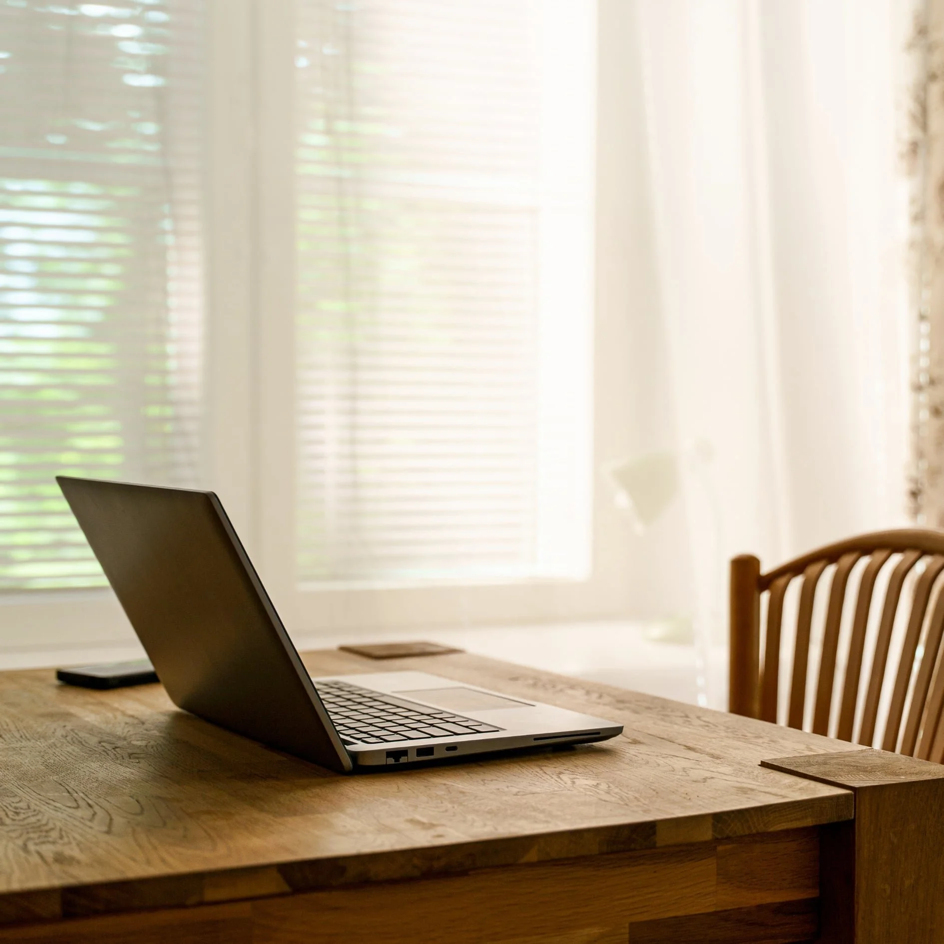 Web designer, Tabitha Stevenson's office with desk, laptop, chair, and window in background.