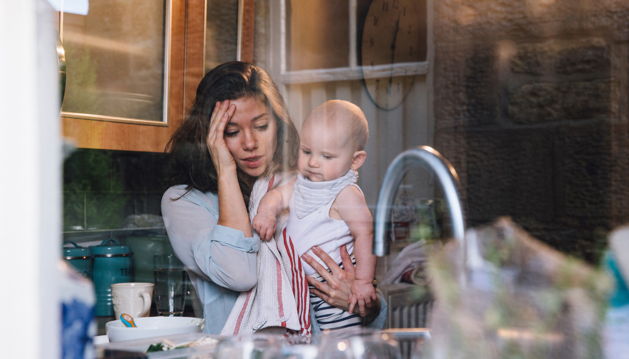 1. Stressed mother holding her baby at home, representing parenting stress, caregiver burnout, overwhelm, and stress management therapy for parents.            Is this conversation helpful so far?