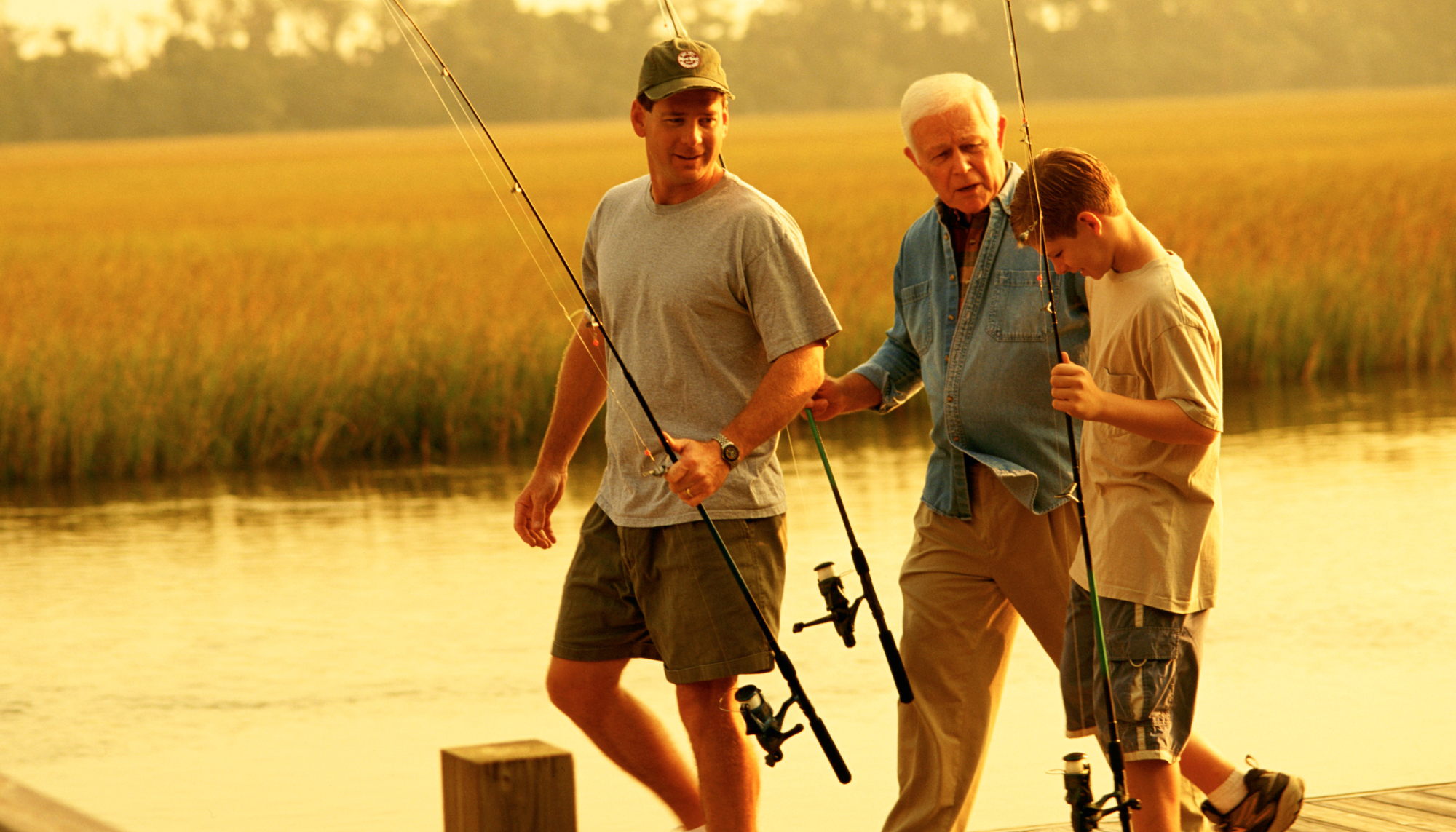 Three generations of men fishing together outdoors, representing men’s mental health, family relationships, and emotional connection.