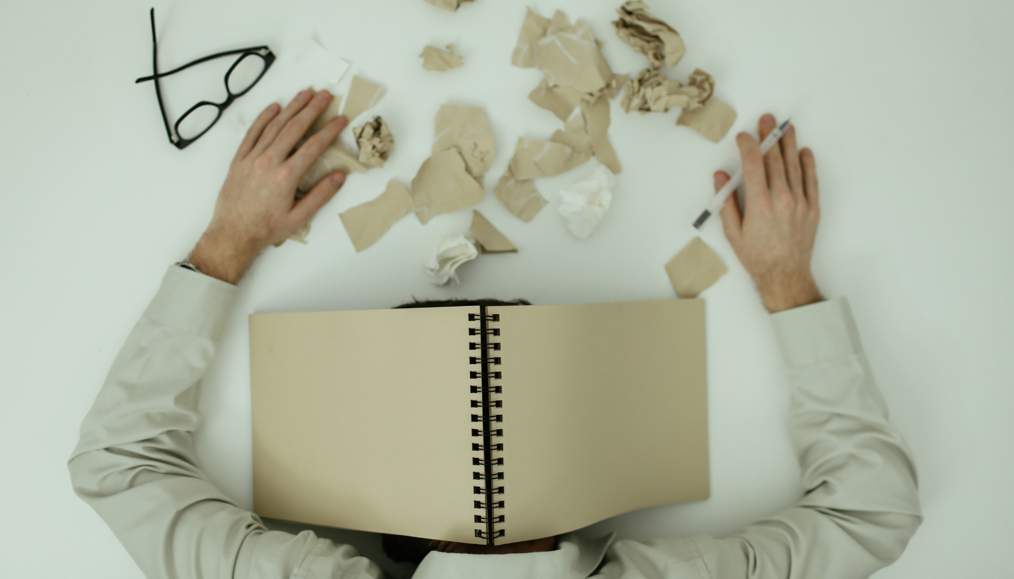 Person feeling overwhelmed at a desk representing challenges with ADHD, executive functioning, and neurodivergence support at Sharp Wellness.